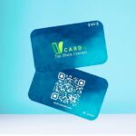 Two blue NFC cards with a branding logo that reads "VCard - Tap, Share, Connect." One card features a QR code and the URL www.vcarde.com.