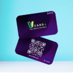 Two purple business cards, one showing the text "vCARDO Tap, Share, Connect" and an NFC symbol, and the other displaying a QR code, a URL, and an ID number against a blue background.